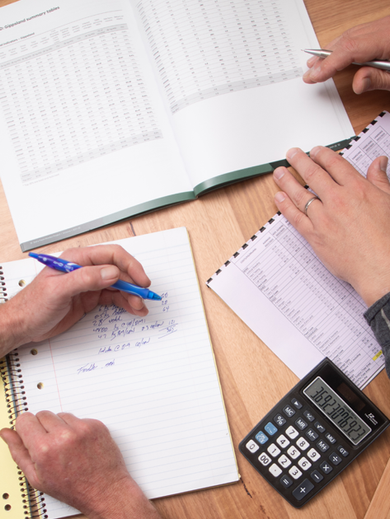 Two farmers are reviewing their farm business performance on a dinning table.