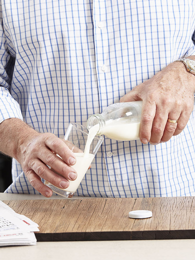 person pouring milk into a glass